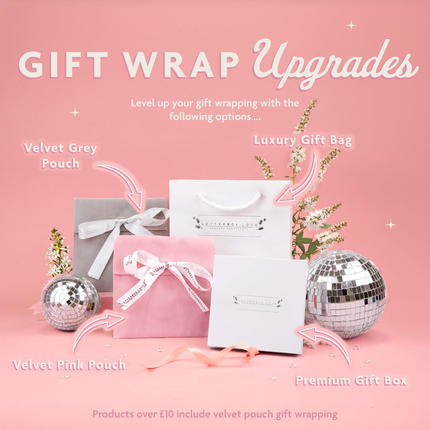 a pink background with a silver gift bag and two silver disco balls