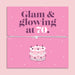 Pink 70th birthday gift card with the text “Glam & glowing at 70” in bold purple and white lettering, featuring a silver and grey adjustable heart charm bracelet across the centre and an illustrated birthday cake below.