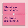 A silver-plated star charm bracelet on a soft, adjustable cord, displayed on a vibrant pink backing card with the message: 