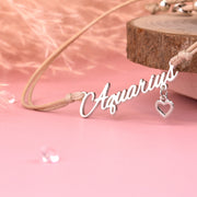 Detail of a friendship bracelet with the star sign "Aquarius". Delicate bracelet with a pink background. A beautiful zodiac gift for someone special.