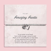 Silver beaded bracelet with heart and flower charms, displayed in a white gift box alongside a card titled "To My Amazing Auntie." The card features a heartfelt message celebrating the love, support, and special bond shared with an aunt.