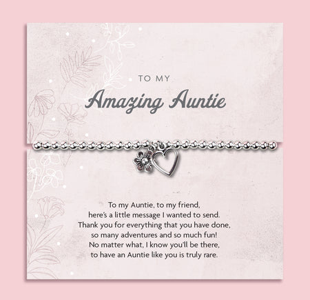 Silver beaded bracelet with heart and flower charms, displayed in a white gift box alongside a card titled 