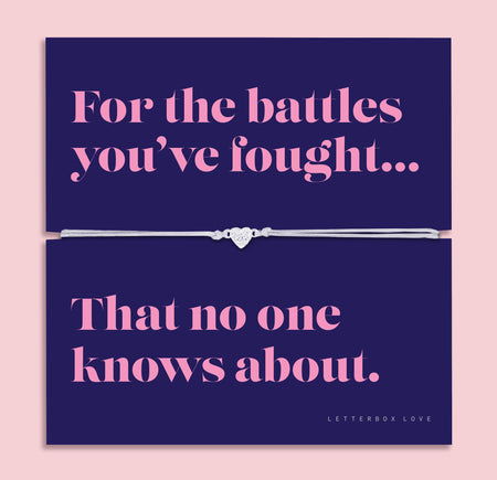 Friendship bracelet with a silver heart charm on an adjustable cord, displayed on a navy card reading “For the battles you’ve fought… that no one knows about” — a supportive bracelet for a friend and meaningful friendship gift by Letterbox Love.