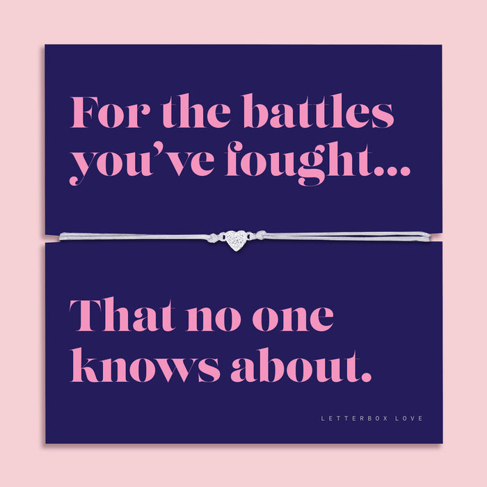 Friendship bracelet with a silver heart charm on an adjustable cord, displayed on a navy card reading “For the battles you’ve fought… that no one knows about” — a supportive bracelet for a friend and meaningful friendship gift by Letterbox Love.