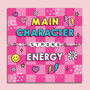 Pink chequered poem card with the bold text saying "Main Character Energy", with a beaded bracelet spelling the word "Strong". An ideal gift for a best friend.