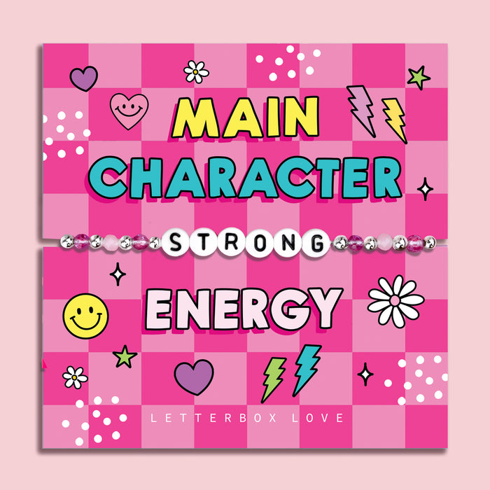 Pink chequered poem card with the bold text saying "Main Character Energy", with a beaded bracelet spelling the word "Strong". An ideal gift for a best friend.