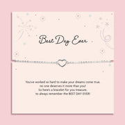 Silver heart charm bracelet displayed on a blush pink “Best Day Ever” poem card with delicate star illustrations. A sentimental silver bracelet gift for graduation, weddings, or milestone celebrations.