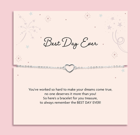 Silver heart charm bracelet displayed on a blush pink “Best Day Ever” poem card with delicate star illustrations. A sentimental silver bracelet gift for graduation, weddings, or milestone celebrations.