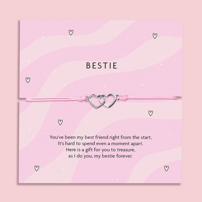 A pink bracelet card with two heart charms, featuring the text "Bestie" and a heartfelt poem expressing friendship. The bracelet is adjustable with a light pink cord, symbolizing the bond between best friends.
