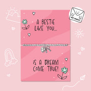 A silver beaded bracelet with a heart and key charm is displayed on a pink gift card that reads 'A BESTIE LIKE YOU.