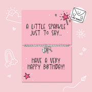 A silver charm bracelet with a heart and key pendant displayed on a pink birthday card that reads 'A LITTLE SPARKLE JUST TO SAY.