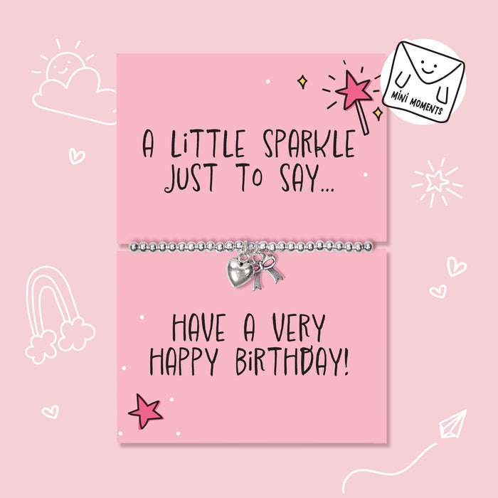 A silver charm bracelet with a heart and key pendant displayed on a pink birthday card that reads 'A LITTLE SPARKLE JUST TO SAY.