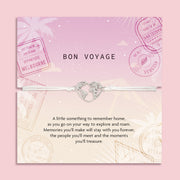 Bracelet with heart-shaped world map charm on a 'Bon Voyage' card with travel stamps. A gift for a friend that is setting off travelling.