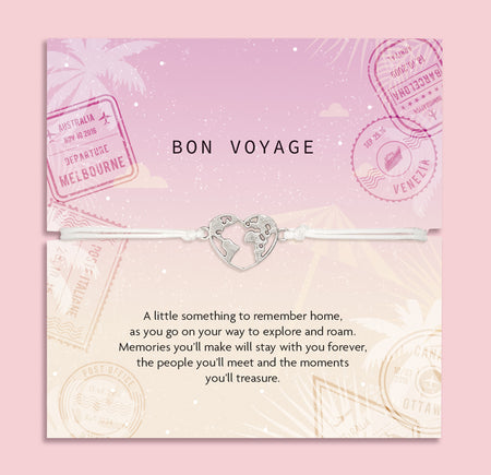 Bracelet with heart-shaped world map charm on a 'Bon Voyage' card with travel stamps. A gift for a friend that is setting off travelling.