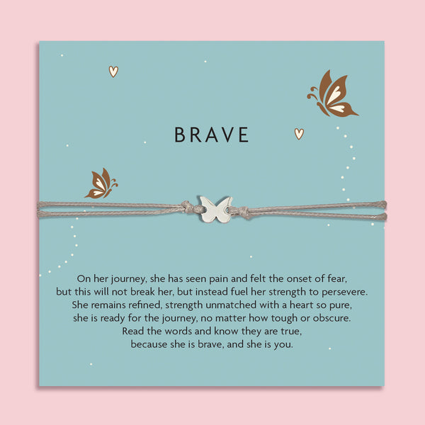 Grey cord bracelet with a silver butterfly charm, displayed on a teal card with butterflies and the word 'Brave'. The card features an inspirational message about strength, resilience, and courage. An empowering gift from Letterbox Love.