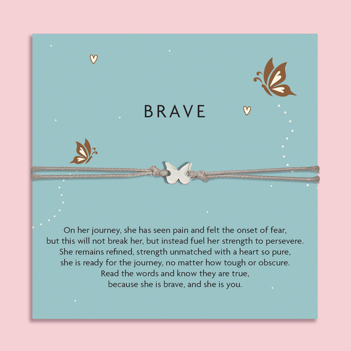 Grey cord bracelet with a silver butterfly charm, displayed on a teal card with butterflies and the word 'Brave'. The card features an inspirational message about strength, resilience, and courage. An empowering gift from Letterbox Love.