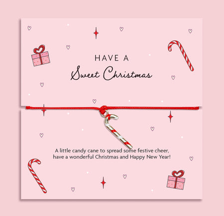 Pink Christmas card with festive illustrations and adjustable bracelet featuring a silver candy cane charm, gift idea for Secret Santa or stocking filler.
