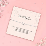 Bracelet with heart charm on a 'Best Day Ever' card on a pink background