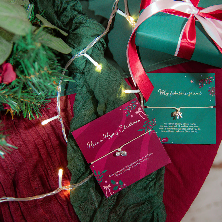 A christmas table with green and ruby colour drapes and wrapped presents. Central are two meaningful gifts from Letterbox Love for Xmas. One reads 'have a happy Christmas' and the other 'my fabulous friend.' Making a beautiful gift for a friend at xmas