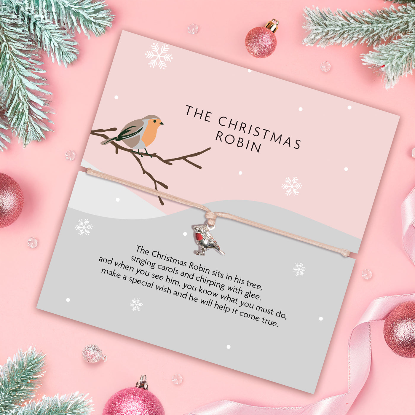 Card with Christmas robin illustration and text on a pink background with festive decorations.