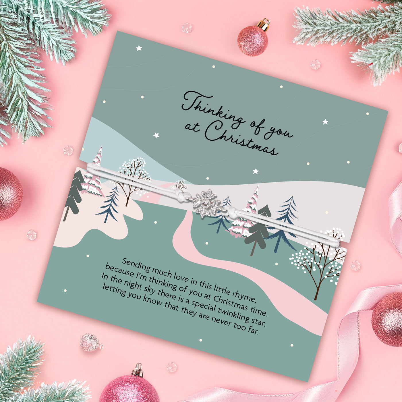 Christmas card with winter scene and text on a pink background with ornaments and tree branches. A beautiful bracelet for her.