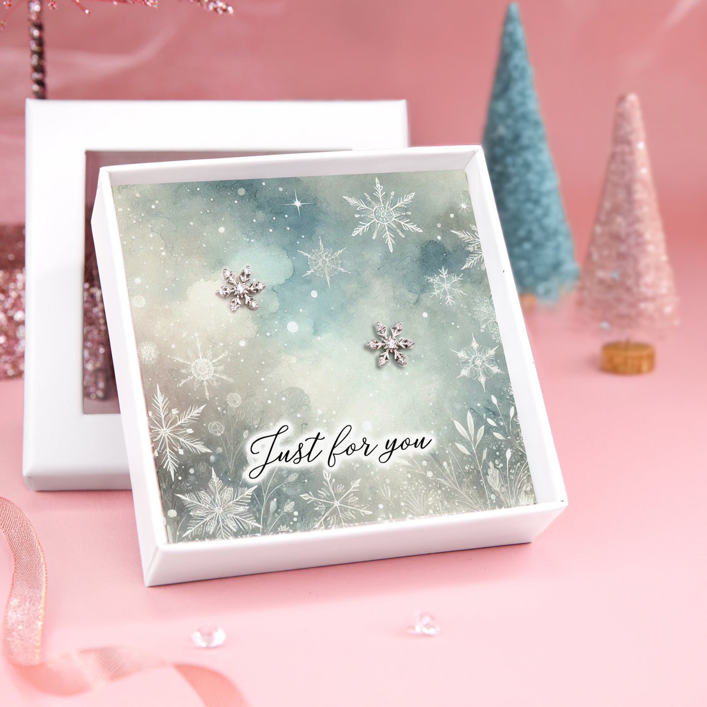 A pair of silver star earrings displayed on a card with a beautiful winter village scene, featuring the text 