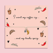 Adjustable book lover bracelet with silver-plated heart charm and gold-tone croissant charm on a peach “I want my coffee icy… and my books spicy” card.