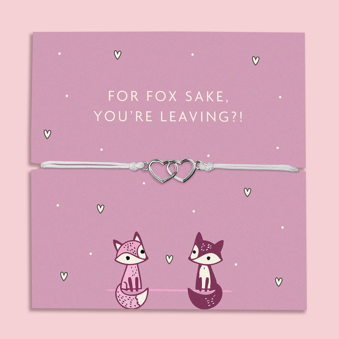 A lilac adjustable bracelet featuring two interlinked heart charms, displayed on a lilac backing card with the playful message "For Fox Sake, You’re Leaving?!" accompanied by cute fox illustrations. Perfect as a farewell gift.