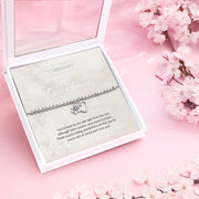Silver beaded bracelet with heart and flower charms, presented in a white gift box with a sentimental card titled "To My Lovely Cousin." The card includes a heartfelt message celebrating the special bond between cousins.