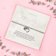 A silver beaded bracelet with a heart and flower charm displayed on a card reading "To my Lovely Cousin" from Letterbox Love, set against a soft pink background with eucalyptus leaves and small crystals. The card features a heartfelt poem, making it an ideal sentimental gift for a cousin.
