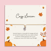 Adjustable neutral cord bracelet with silver-tone acorn charm displayed on a Cozy Season autumn sentiment card with pumpkins, leaves and a heartfelt friendship poem