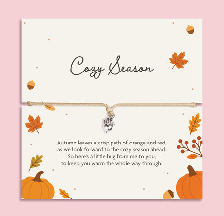 Adjustable neutral cord bracelet with silver-tone acorn charm displayed on a Cozy Season autumn sentiment card with pumpkins, leaves and a heartfelt friendship poem