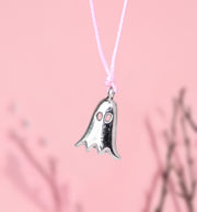 Silver ghost-shaped charm bracelet on a pink cord against a pink background. Cute Autumn jewellery for women for halloween and fall