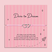 Dare to Dream encouragement bracelet with interlinked heart charms on pink adjustable cord, displayed on inspirational keepsake card with motivational poem, thoughtful gift for someone chasing their dreams.