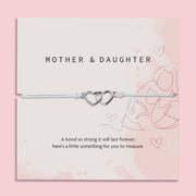 Silver bracelet with interlocking hearts on a 'Letterbox Love' card with text on a pink background. A meaningful gift under £10 for a mother and daughter