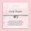 A silver beaded bracelet with a heart and flower charm displayed on a card reading 