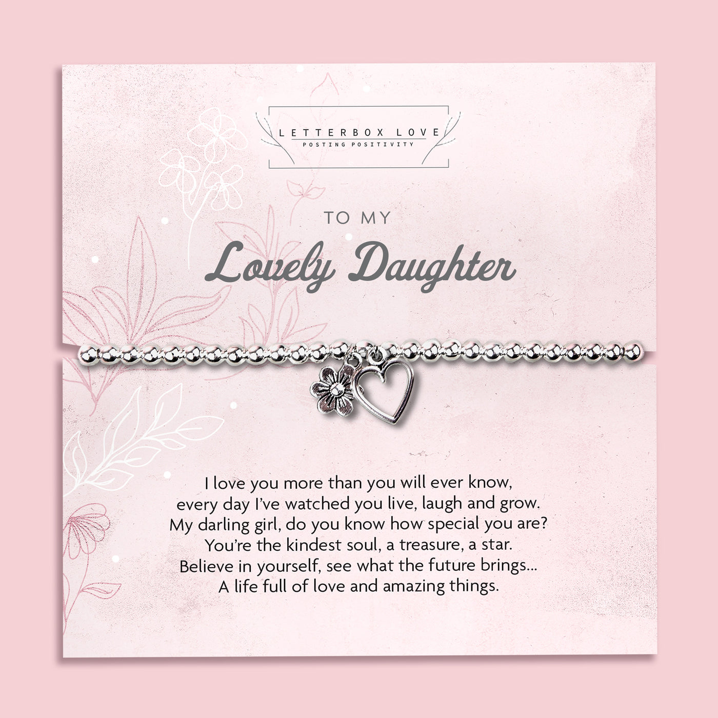 A silver beaded bracelet with a heart and flower charm displayed on a card reading 