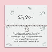A pink background with an illustrated dog poem card with thoughtful poem about being a Dog Mum. The bracelet around the card is a silver-plated beaded bracelet with a cute dog paw charm.