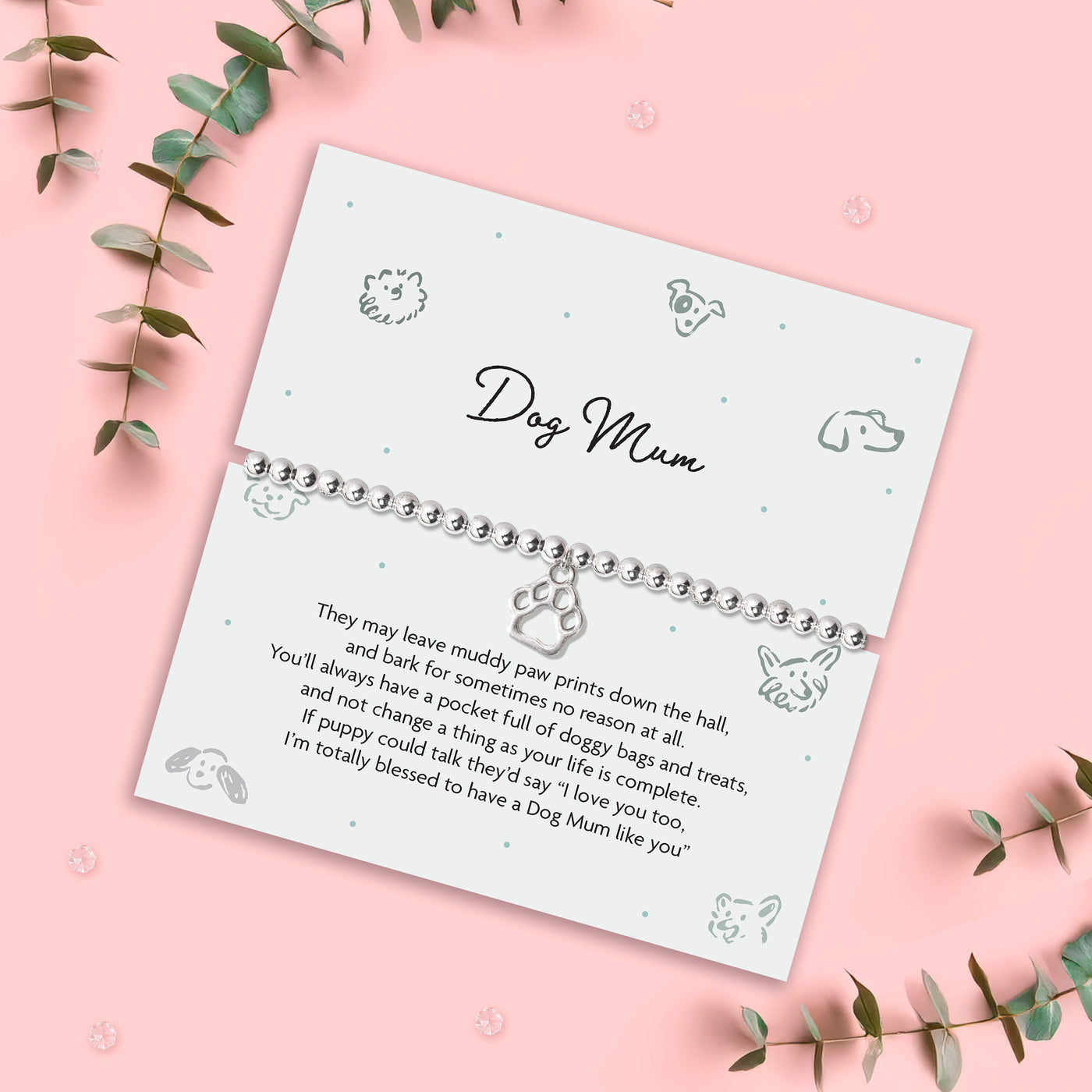 Bracelet with 'Dog Mum' poem card and meaningful poem for dog lovers, on a pink background with decorative leaves. The bracelet is silver-plated and elasticated
