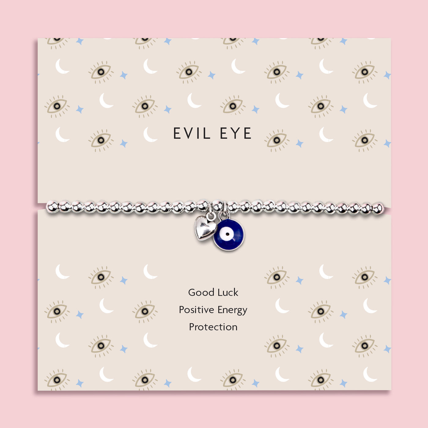 Silver-plated beaded bracelet featuring a deep blue evil eye charm and a small heart charm, displayed on a cream sentiment card with moon and star illustrations and the words “Good Luck, Positive Energy, Protection.