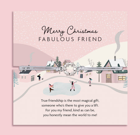 Merry Christmas Fabulous Friend bracelet featuring a silver wreath charm on an adjustable cord, presented on a festive card with a snowy village scene, houses, and ice skaters. Includes a white soft pouch for gifting and safekeeping. Perfect Christmas jewellery gift for a best friend, Secret Santa present, or stocking filler. A thoughtful holiday keepsake, ideal for celebrating friendship and spreading joy during the festive season.