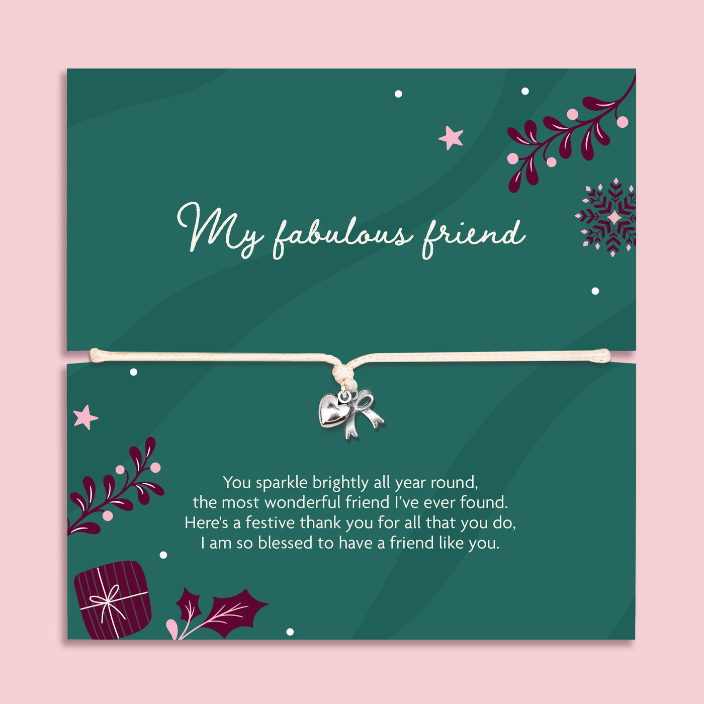 A square green xmas bracelet gift with decorative illustrations and a beige cord across the centre with a silver bow and heart charm. The top half reads 'My fabulous friend' and the bottom half has a festive thank-you message, all on a light pink background.