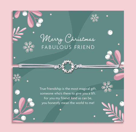 Merry Christmas Fabulous Friend bracelet featuring a silver wreath charm on an adjustable cord, presented on a festive card with snowflakes, mistletoe, and holiday designs. Includes a white soft pouch for gifting and safekeeping. Perfect Christmas jewellery gift for a best friend, Secret Santa present, or stocking filler. A thoughtful and meaningful festive keepsake, ideal for celebrating friendship and spreading holiday cheer during the Christmas season.