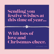 Festive star bracelet featuring a sparkling cubic zirconia star charm on an adjustable cord, presented on a bold navy Christmas card with the message “Sending you festive wishes at this time of year… With lots of love and Christmas cheer.” Includes a soft white pouch for gifting and safekeeping. A thoughtful Christmas jewellery gift, perfect as a stocking filler and Secret Santa present.