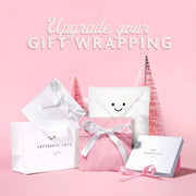 Gift wrapping products with 'Letterbox Love' branding on a pink background.