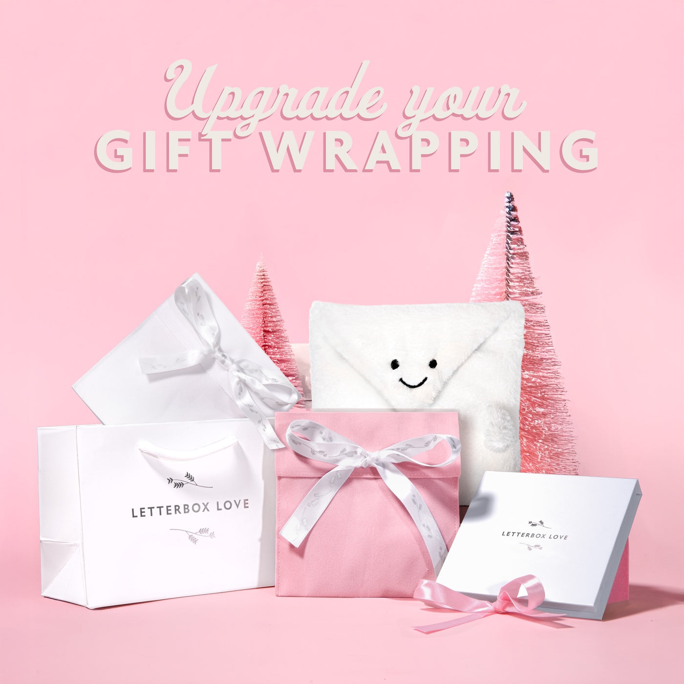 Gift wrapping products with 'Letterbox Love' branding on a pink background.