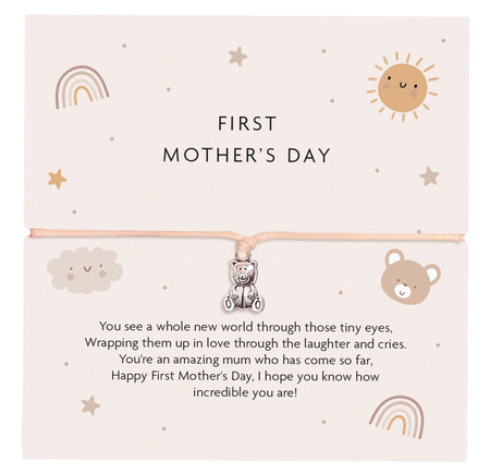 First Mother's Day bracelet featuring a cute teddy bear charm on a peach-coloured cord, with a soft pastel card design including a rainbow, sun, cloud, and bear illustrations. The card reads a heartfelt message for a first-time mother.