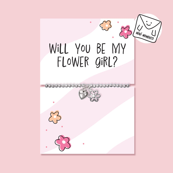 Children’s silver-plated flower girl proposal bracelet with heart and flower charms displayed on a pink “Will You Be My Flower Girl?” card.
