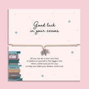 Good luck exam bracelet with open book charm on adjustable cord, displayed on a motivational exam gift card with poem, student encouragement gift