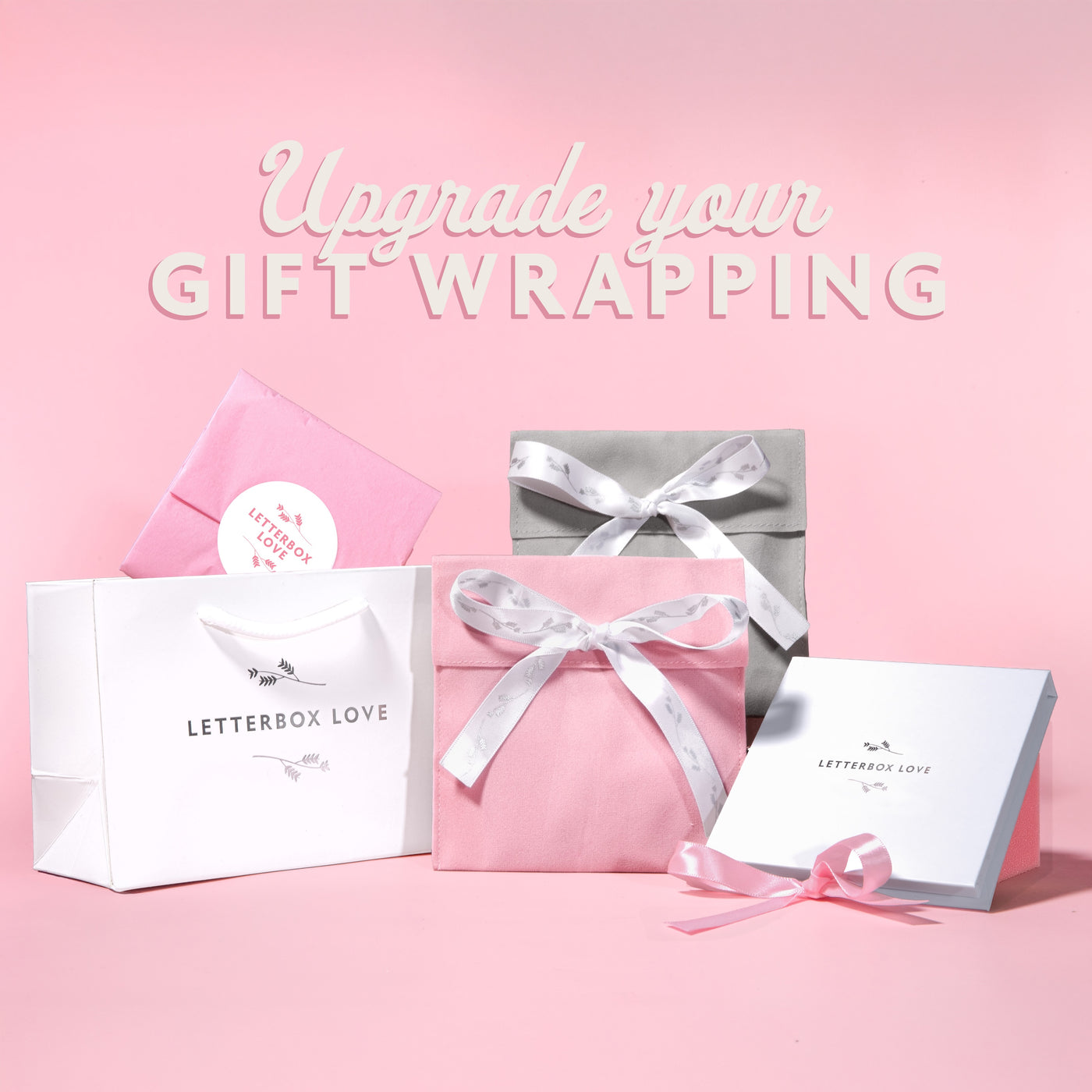 Gift wrapping products with 'Letterbox Love' branding on a pink background.